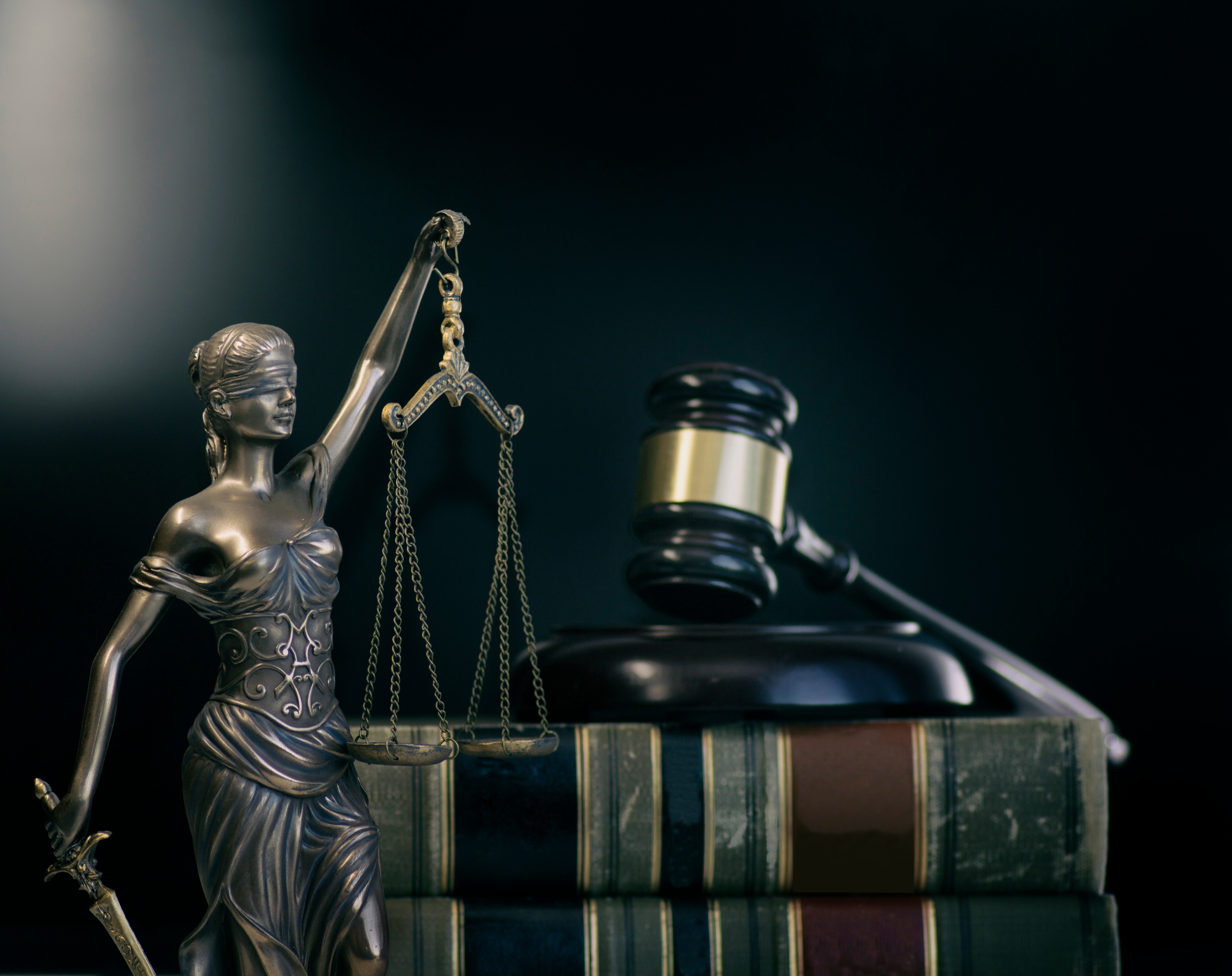 Stylised legal imagery: Lady Justice, gavel, and law books
